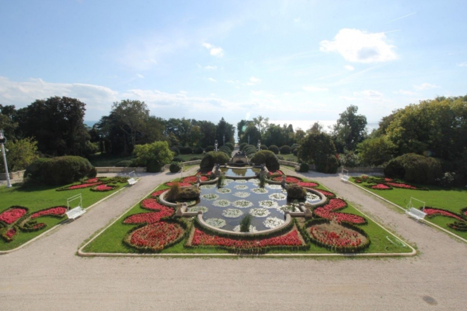Palace and park in Louis XIII French château style characterized by jointed brickwork, a high mansard roof with copper cladding and a clock tower.