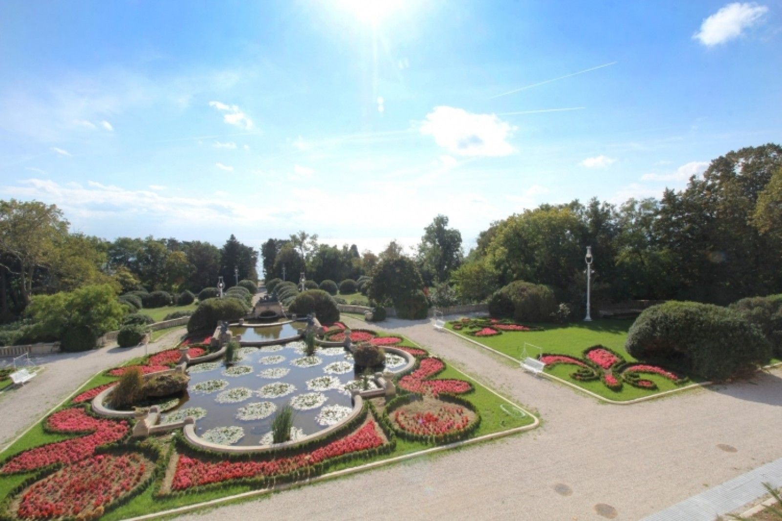 Palace and park in Louis XIII French château style characterized by jointed brickwork, a high mansard roof with copper cladding and a clock tower.
