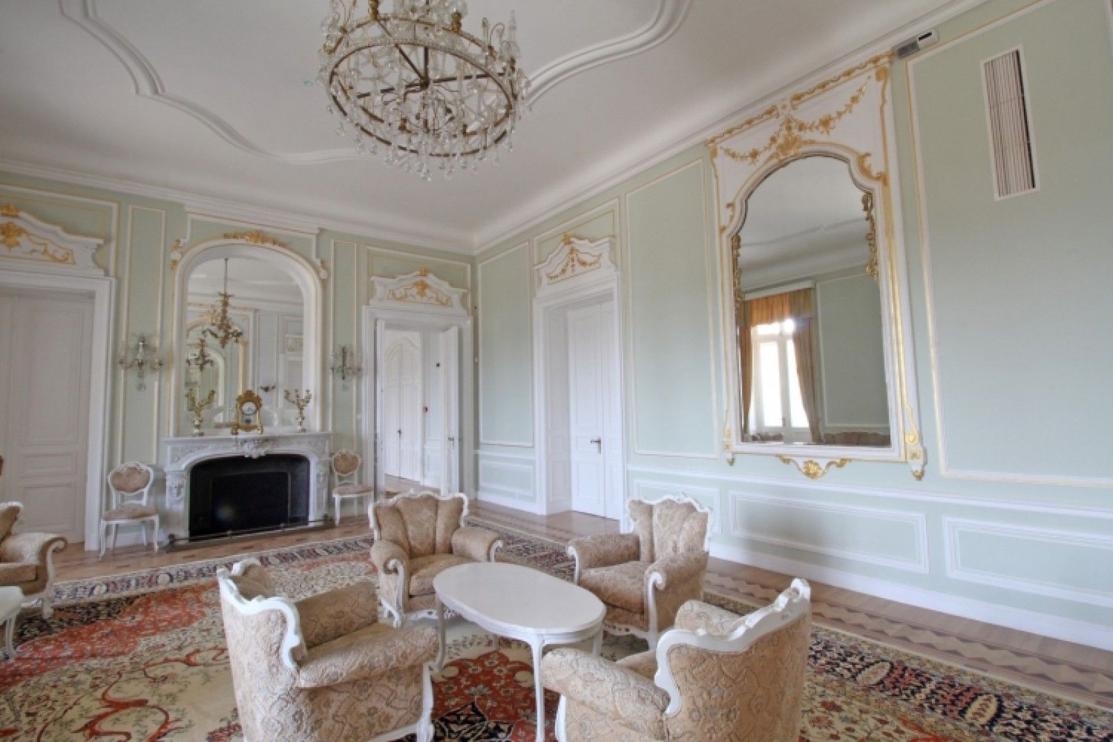 Palace in Louis XIII French château style characterized by jointed brickwork, a high mansard roof with copper cladding and a clock tower.