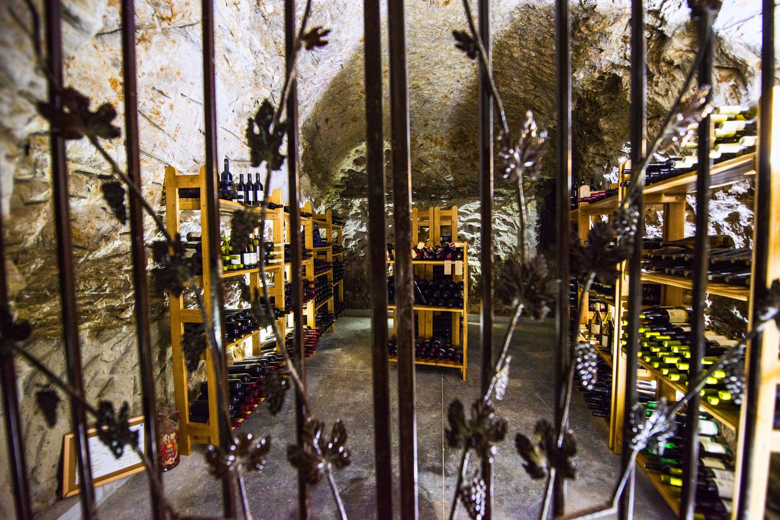 Underground treasury with old bottles of wine, locked behind a metal door