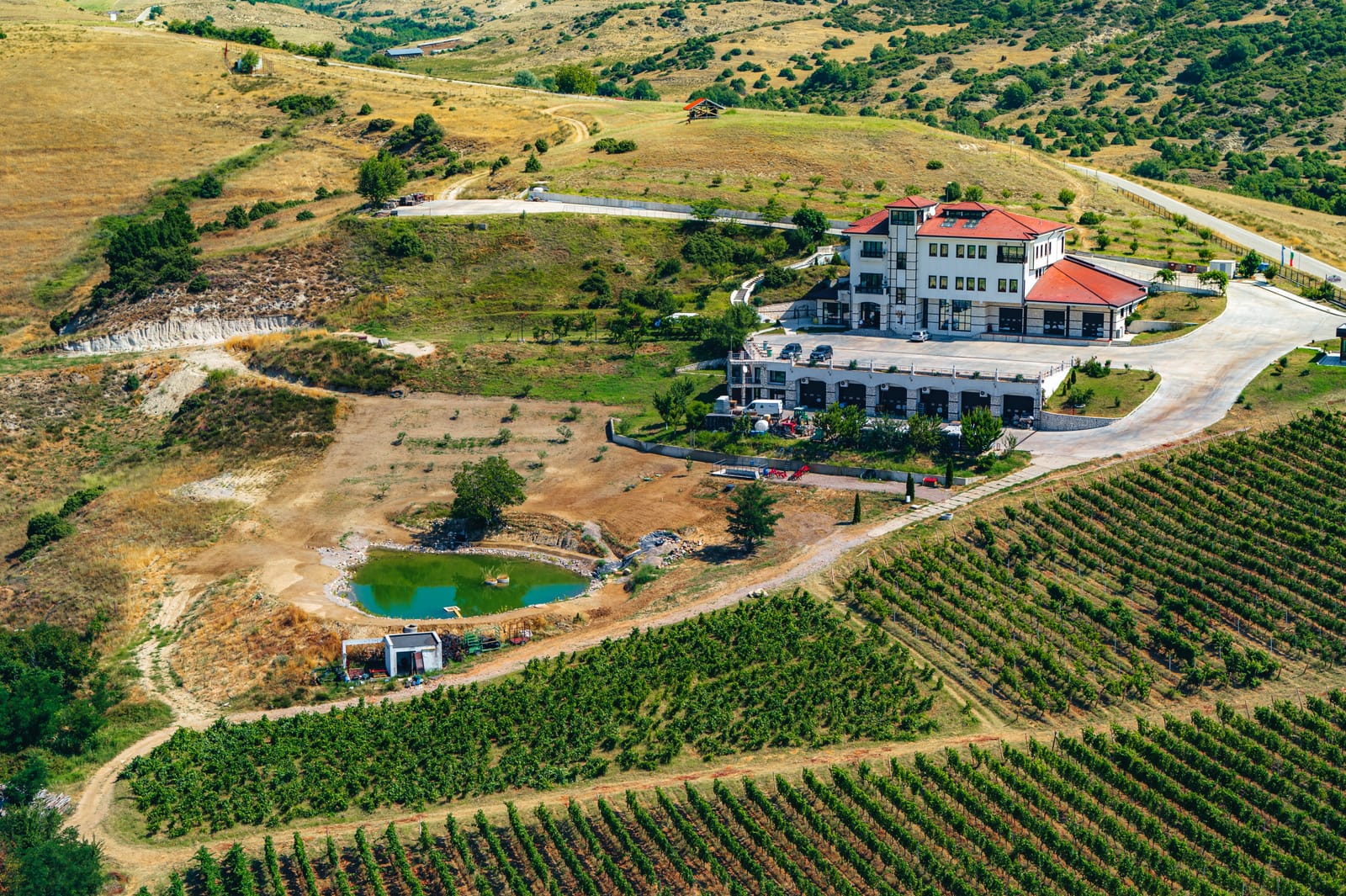 Drone view of winery, vineyards, and pond