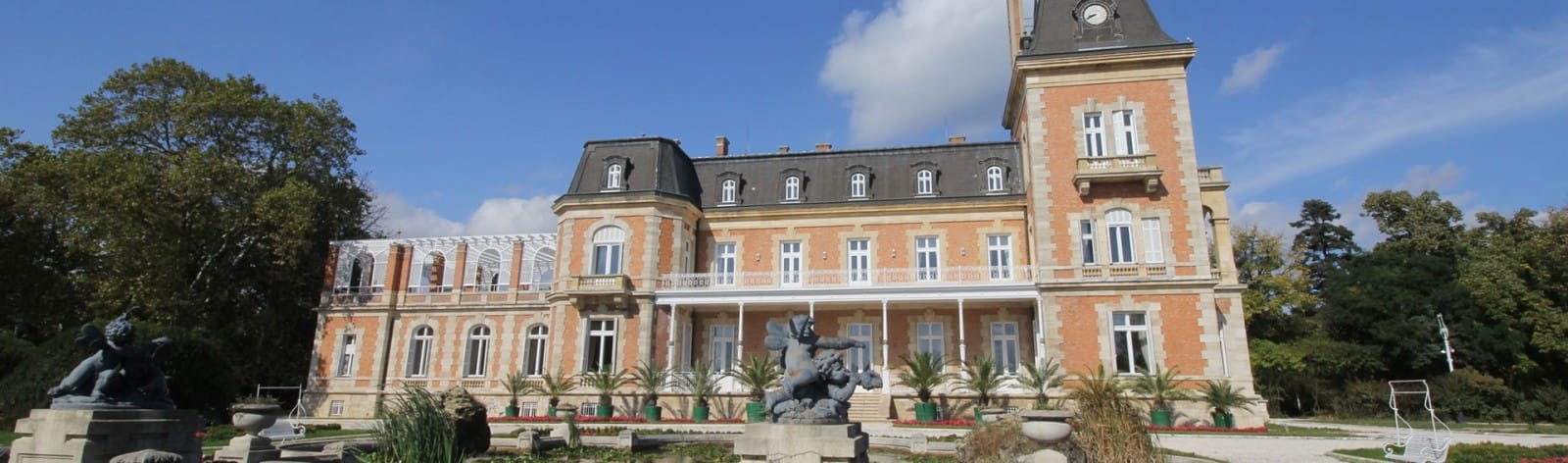 Palace in Louis XIII French château style characterized by jointed brickwork, a high mansard roof with copper cladding and a clock tower.