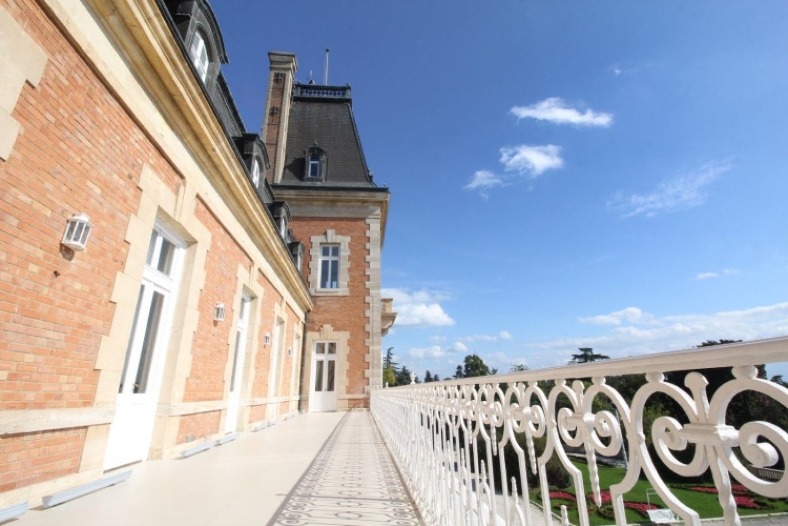 Palace in Louis XIII French château style characterized by jointed brickwork, a high mansard roof with copper cladding and a clock tower.