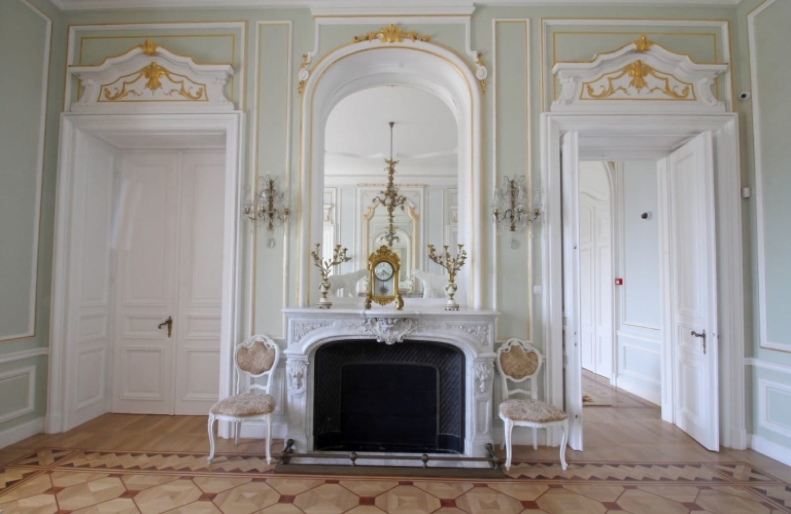 Palace in Louis XIII French château style characterized by jointed brickwork, a high mansard roof with copper cladding and a clock tower.