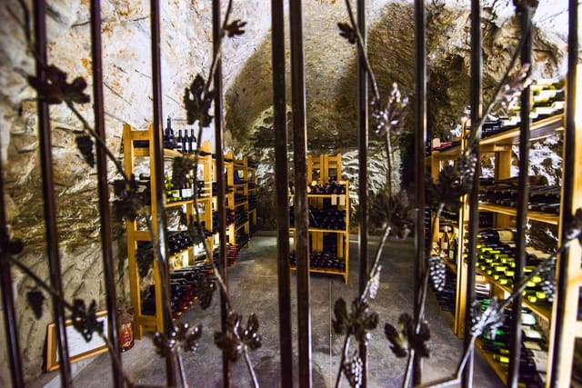 Underground treasury with old bottles of wine, locked behind a metal door