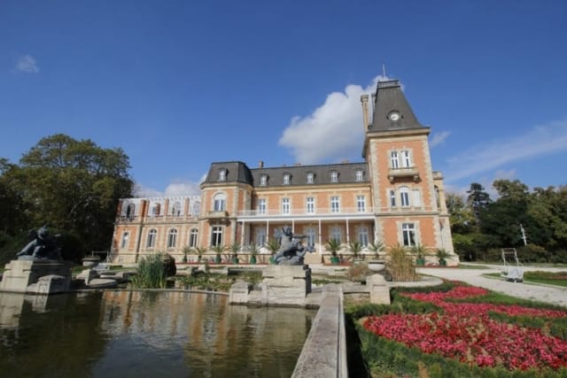 Evxinograd Palace, built in 1882, in Louis XIII French château style characterized by jointed brickwork, a high mansard roof with copper cladding and a clock tower.