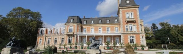Evxinograd Palace, built in 1882, in Louis XIII French château style characterized by jointed brickwork, a high mansard roof with copper cladding and a clock tower.